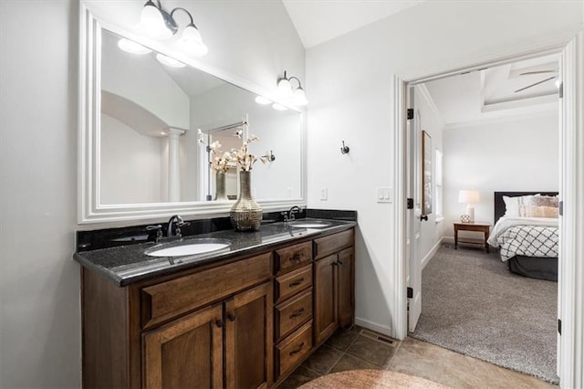 ensuite bathroom with ensuite bathroom, double vanity, a sink, and baseboards