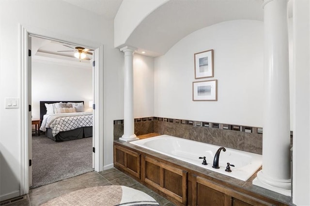 ensuite bathroom with ceiling fan, a garden tub, visible vents, ensuite bath, and ornate columns