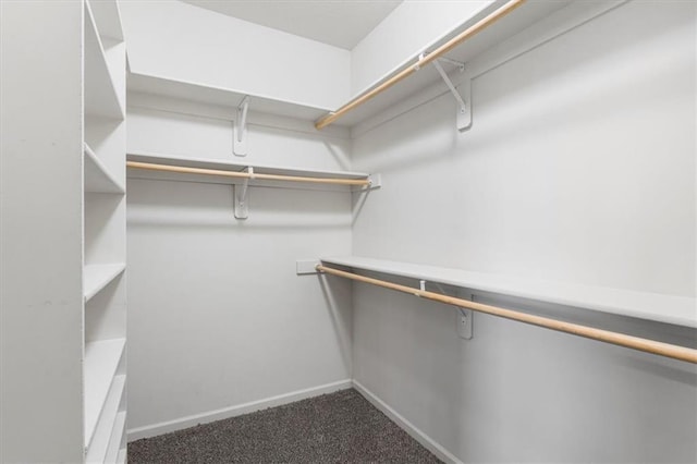 spacious closet featuring dark carpet