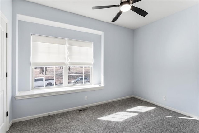 spare room featuring carpet floors, baseboards, visible vents, and ceiling fan