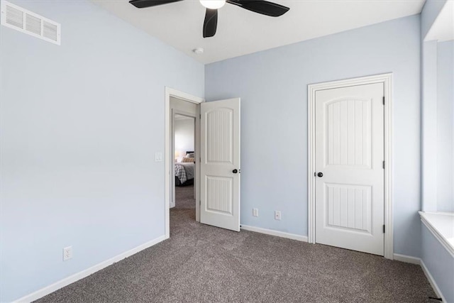 unfurnished bedroom with carpet floors, a ceiling fan, visible vents, and baseboards