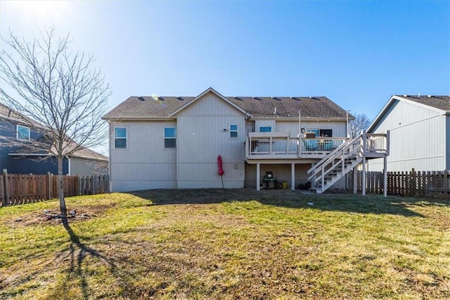 rear view of house with a lawn, fence, a deck, and stairs