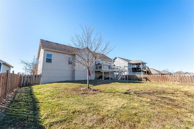 rear view of property featuring a fenced backyard, stairs, a deck, and a yard