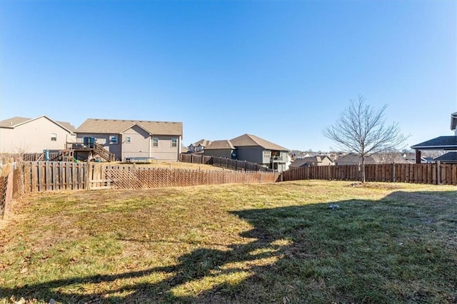 view of yard with a fenced backyard and a residential view