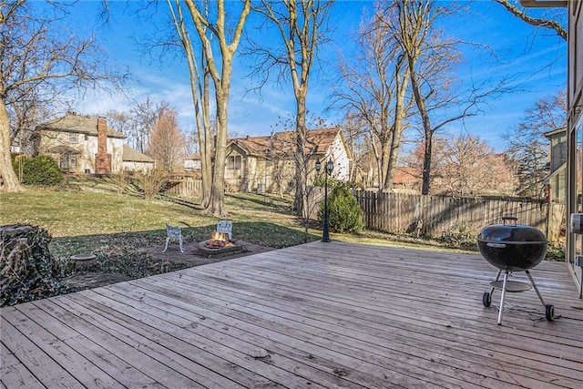 wooden deck with fence, an outdoor fire pit, a yard, a residential view, and a grill