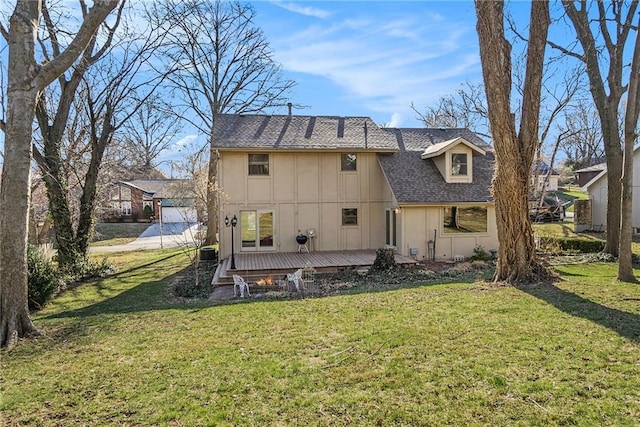 rear view of property featuring cooling unit, a wooden deck, a shingled roof, a lawn, and board and batten siding