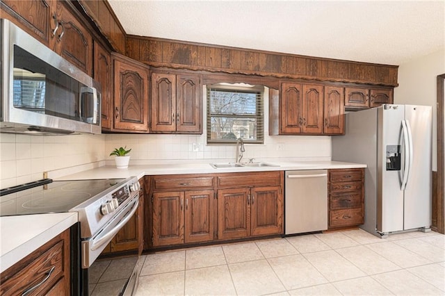 kitchen with light countertops, tasteful backsplash, appliances with stainless steel finishes, and a sink