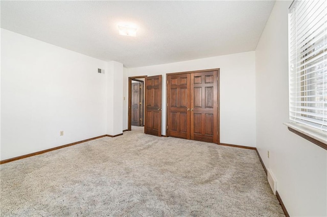 unfurnished bedroom featuring carpet flooring, baseboards, and visible vents