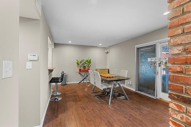 dining space featuring baseboards, wood finished floors, and recessed lighting