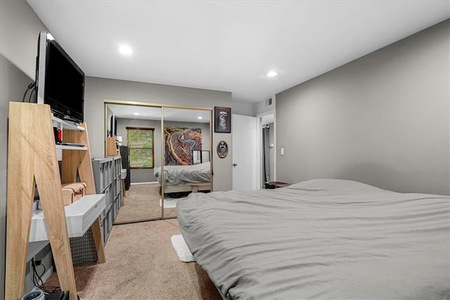 bedroom with recessed lighting, a closet, light colored carpet, and visible vents