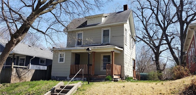 american foursquare style home featuring a chimney and a vegetable garden