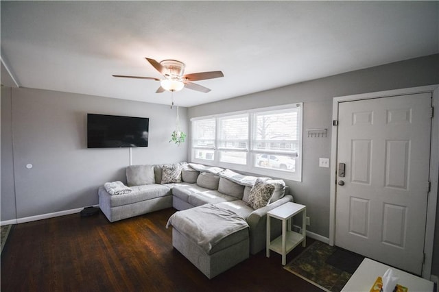 living room featuring ceiling fan, baseboards, and wood finished floors