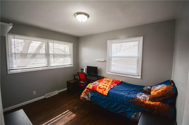 bedroom featuring baseboards, visible vents, and wood finished floors