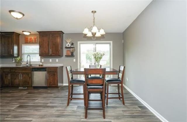 dining area featuring baseboards, a notable chandelier, and wood finished floors