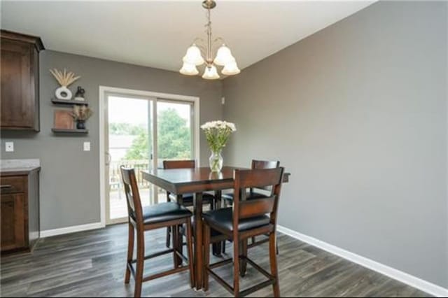 dining room with dark wood-style flooring, an inviting chandelier, and baseboards