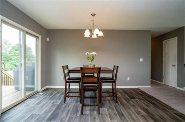 dining room with dark wood-style flooring, baseboards, and an inviting chandelier