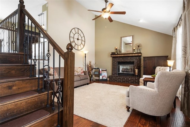 living room with high vaulted ceiling, a ceiling fan, wood finished floors, a fireplace, and stairs