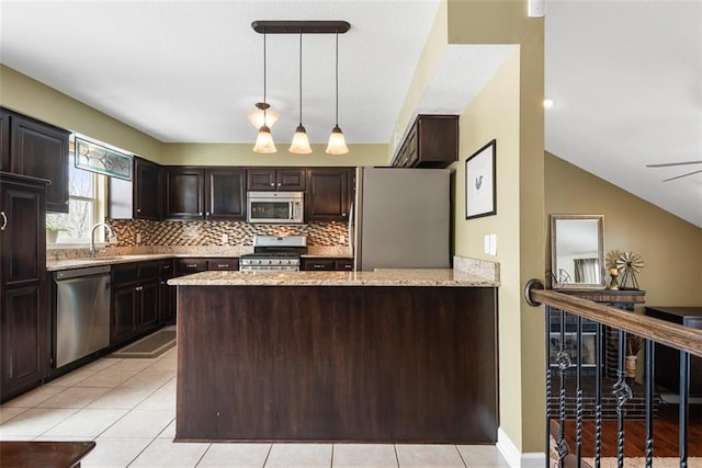 kitchen featuring light stone counters, decorative backsplash, appliances with stainless steel finishes, and dark brown cabinetry