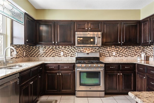 kitchen featuring a sink, stainless steel appliances, dark brown cabinets, and decorative backsplash