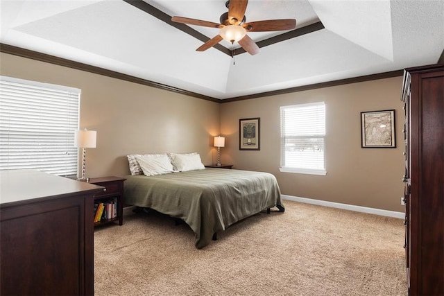 bedroom with baseboards, light carpet, a raised ceiling, and crown molding