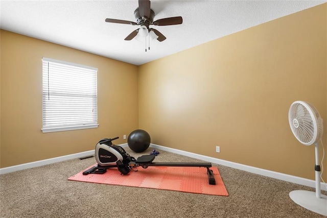 workout area with a textured ceiling, baseboards, carpet floors, and ceiling fan