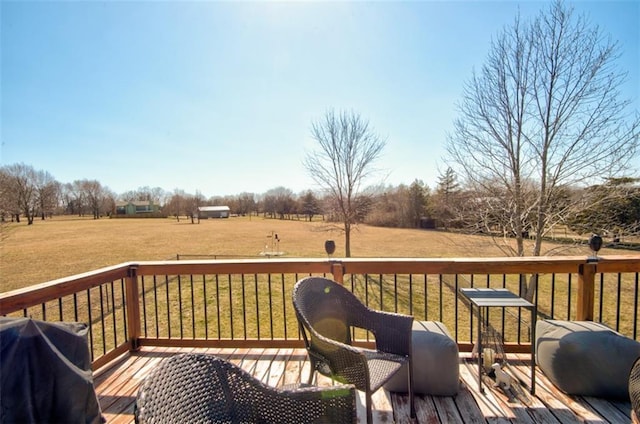 wooden terrace with area for grilling, a yard, and a rural view