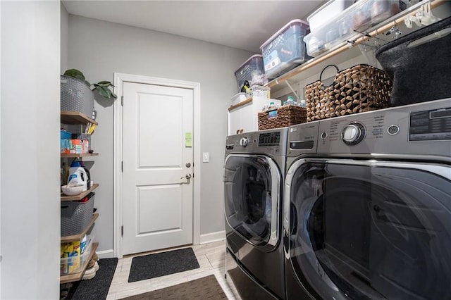 clothes washing area with laundry area, light tile patterned floors, baseboards, and separate washer and dryer