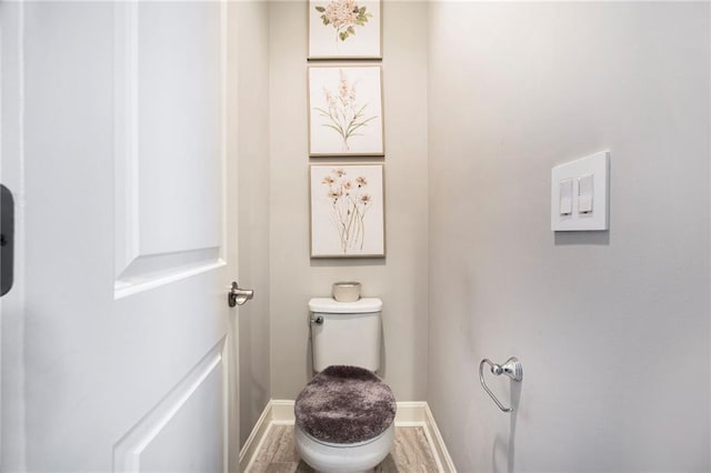 bathroom featuring baseboards, toilet, and wood finished floors