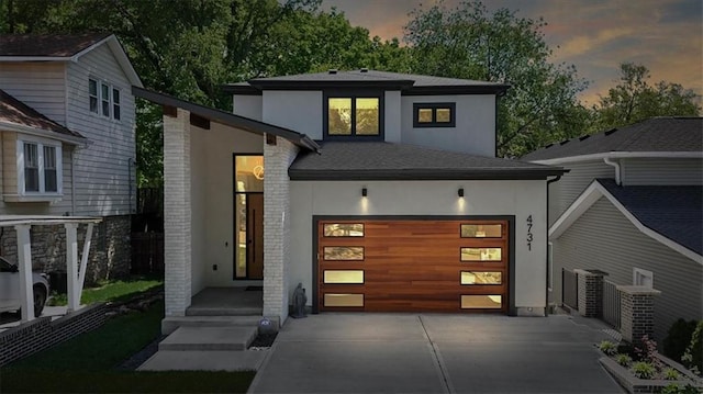 4731 Fairmount Ave, Kansas City, MO 64112 - contemporary house featuring stucco siding, driveway, and a garage