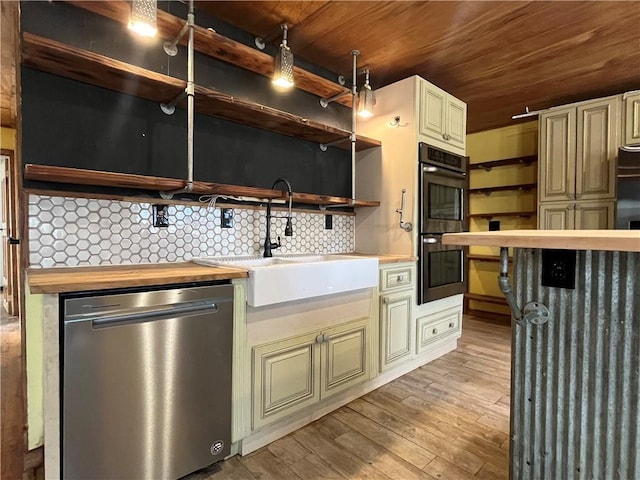 kitchen with cream cabinetry, open shelves, wooden counters, a sink, and dishwasher