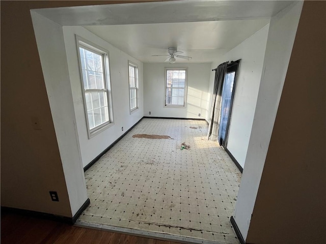 spare room with tile patterned floors, a ceiling fan, and baseboards