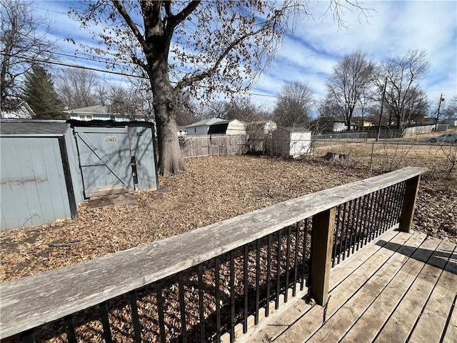 deck featuring a fenced backyard, an outdoor structure, and a storage unit