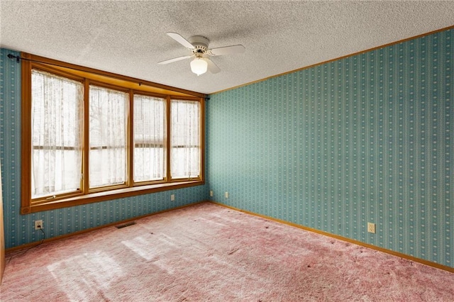 unfurnished room featuring visible vents, a textured ceiling, carpet flooring, and wallpapered walls