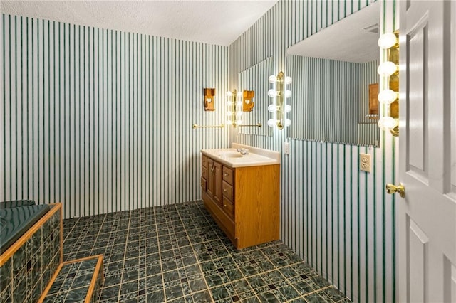 bathroom featuring a textured ceiling and vanity