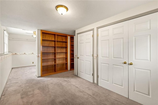 unfurnished bedroom with baseboards, carpet, and a textured ceiling