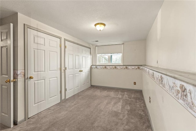 carpeted spare room with a textured ceiling