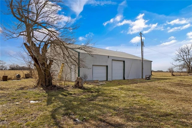 exterior space featuring an outbuilding, a detached garage, and a yard