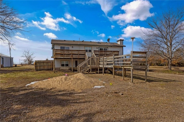 rear view of house with stairs, a deck, and fence