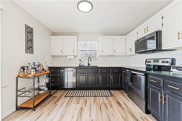 kitchen featuring stainless steel appliances, dark countertops, white cabinets, and dark cabinets