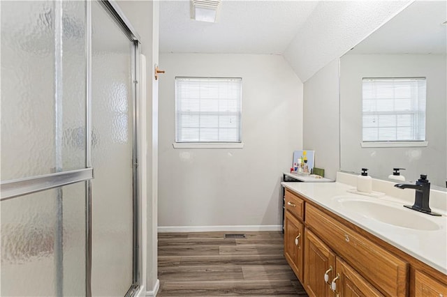 bathroom with a wealth of natural light, a stall shower, wood finished floors, and vanity