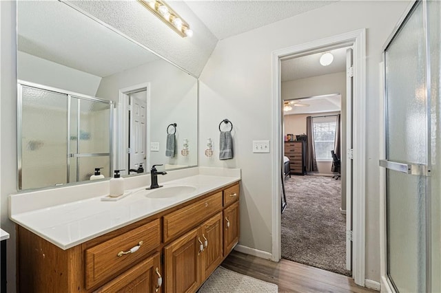 full bath featuring a shower stall, vanity, a textured ceiling, and ensuite bathroom