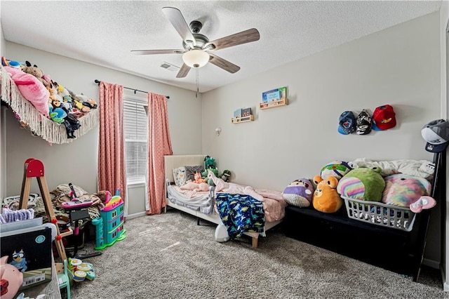 carpeted bedroom featuring a ceiling fan, visible vents, and a textured ceiling