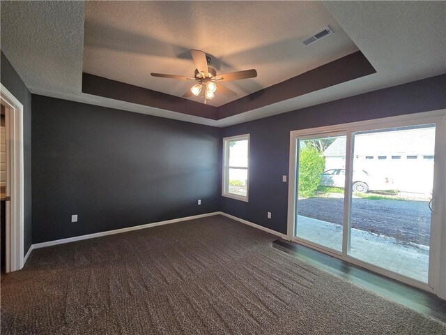 618 N Bates St, Adrian, MO 64720 - carpeted spare room with a tray ceiling, baseboards, and ceiling fan