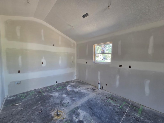542 N Lexington St, Adrian, MO 64720 - unfurnished room with lofted ceiling and a textured ceiling