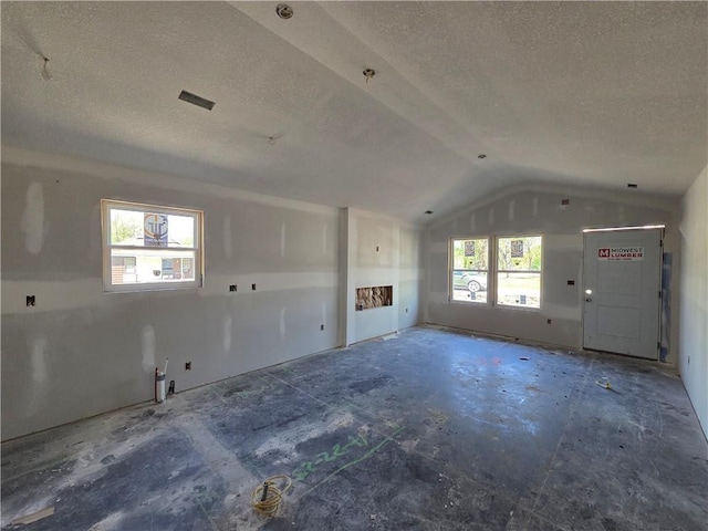 542 N Lexington St, Adrian, MO 64720 - unfurnished living room featuring a textured ceiling and vaulted ceiling