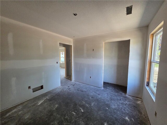 542 N Lexington St, Adrian, MO 64720 - empty room with plenty of natural light and a textured ceiling