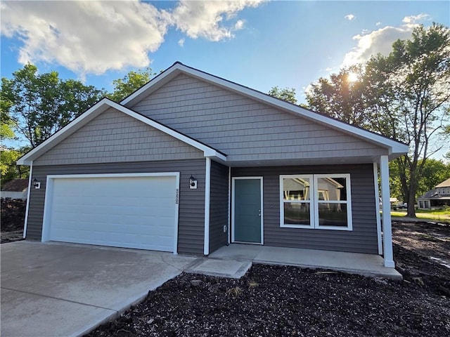 542 N Lexington St, Adrian, MO 64720 - view of front facade with an attached garage, concrete driveway, and covered porch