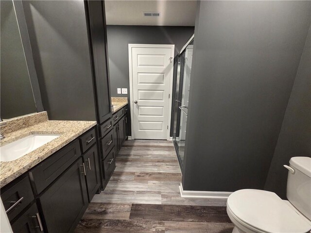 542 N Lexington St, Adrian, MO 64720 - full bath with wood finished floors, vanity, a stall shower, and toilet