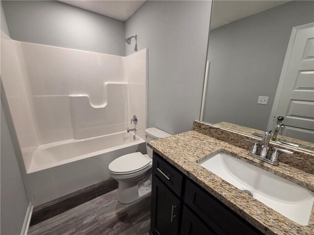542 N Lexington St, Adrian, MO 64720 - full bath featuring wood finished floors, toilet, vanity, and shower / bathtub combination