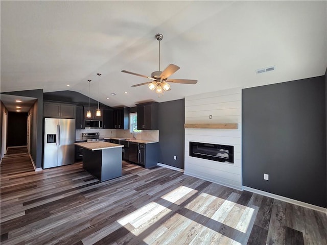540 N Lexington St, Adrian, MO 64720 - kitchen featuring appliances with stainless steel finishes, lofted ceiling, light countertops, a kitchen island, and dark wood finished floors